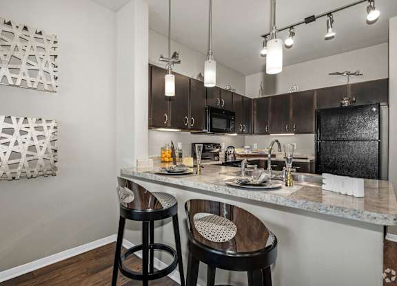 A kitchen with a bar stool and a counter.