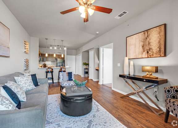A living room with a grey couch and a blue rug.