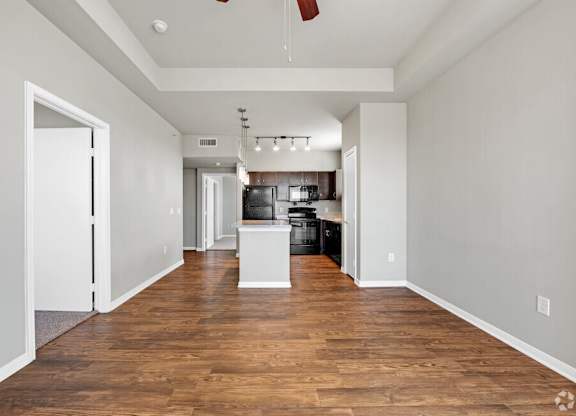 A spacious room with wooden floors and white walls.