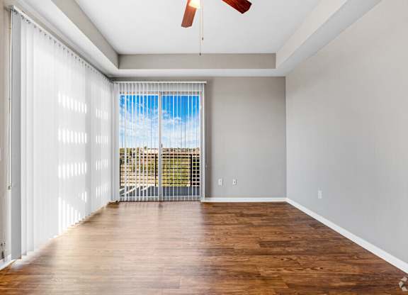 A room with a sliding glass door leading to a balcony.