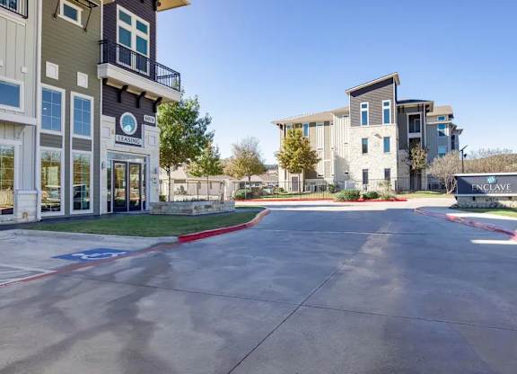 A parking lot in front of a building with a sign that says