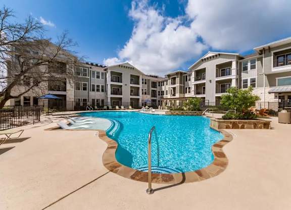 A swimming pool in front of apartment buildings.