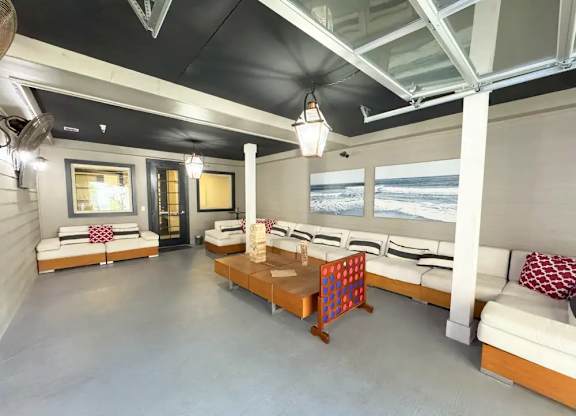 A room with a long couch and a table with a puzzle on it.