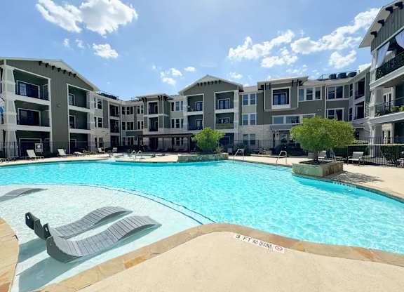 A swimming pool in front of apartment buildings.