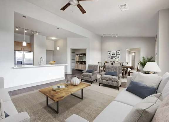 A living room with a white couch, a wooden coffee table, and a ceiling fan.