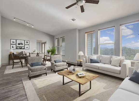 A living room with a white couch, a coffee table, and a ceiling fan.