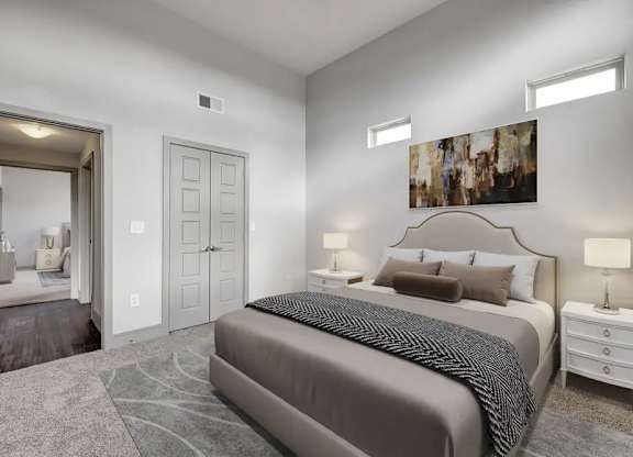 A bedroom with a large bed and a painting on the wall.