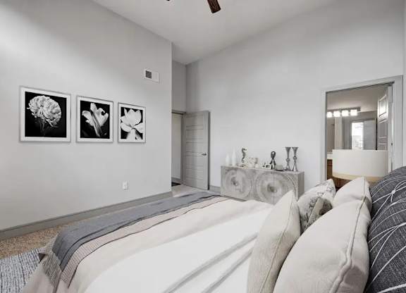 Three framed pictures hang on a white wall above a bed.