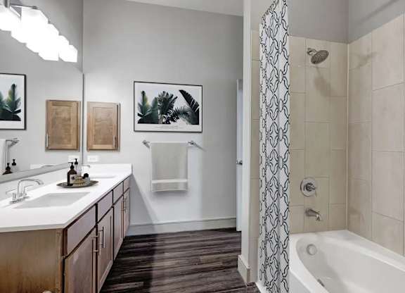 A bathroom with a white sink and a white bathtub.