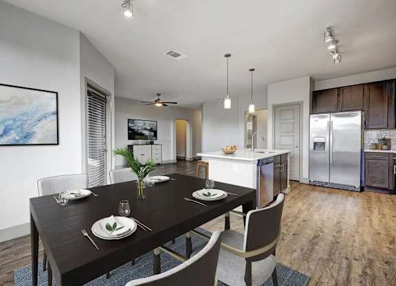 A modern dining room with a wooden table set for two.