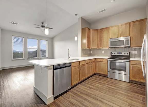 A modern kitchen with wooden cabinets and stainless steel appliances.
