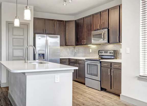 A kitchen with brown cabinets and a white island.