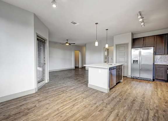 A kitchen with a white island and wooden floors.