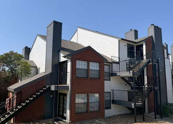 A modern house with a red brick base and white upper floors.
