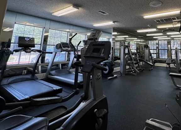 A gym with treadmills, elliptical machines, and other exercise equipment.