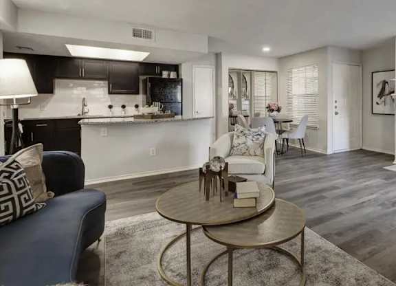A modern living room with a fireplace and a dining area in the background.