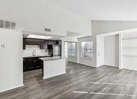 A kitchen with white cabinets and a black countertop.
