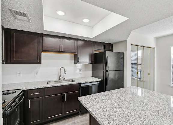 A kitchen with granite countertops and stainless steel appliances.
