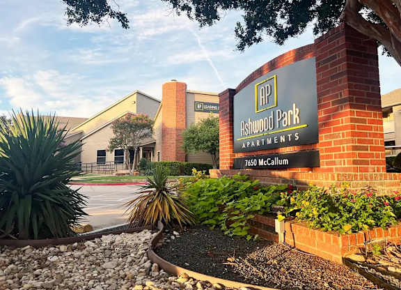The front of Ashwood Park Apartments is shown with a sign and landscaping.
