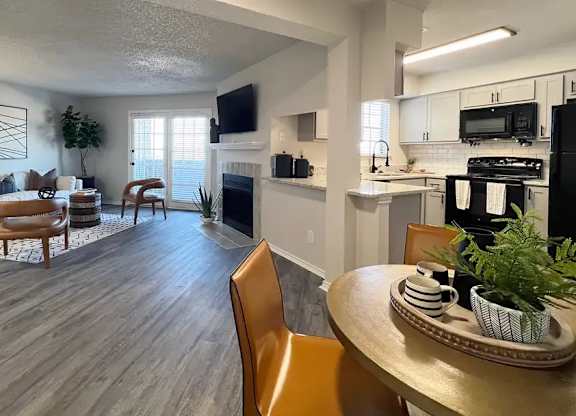 A modern living room with a fireplace and a dining table set for two.