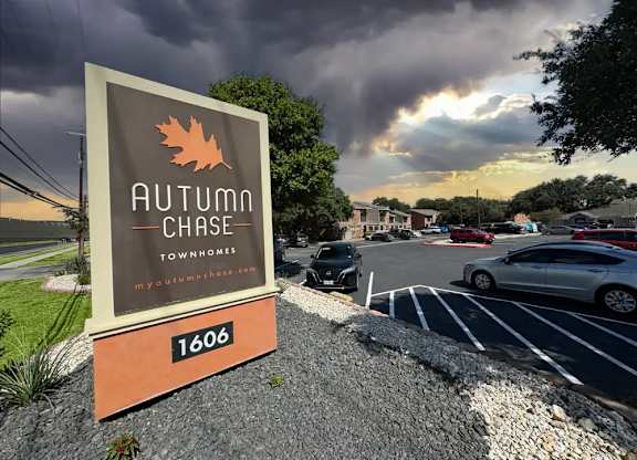 A sign for Autumn Chase Townhomes with a maple leaf logo.