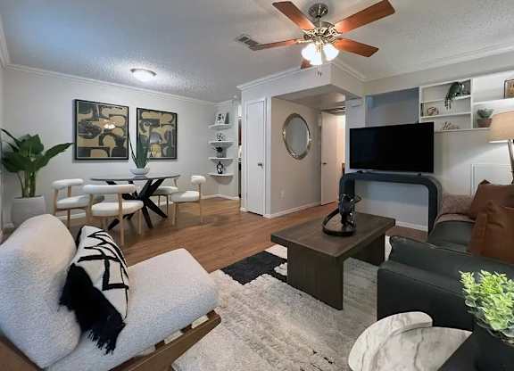 A living room with a white couch and a black and white striped pillow.