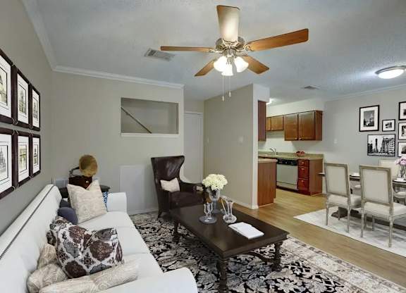 A living room with a white couch and a ceiling fan.