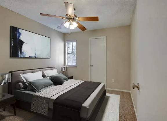 A bedroom with a large bed and a ceiling fan.