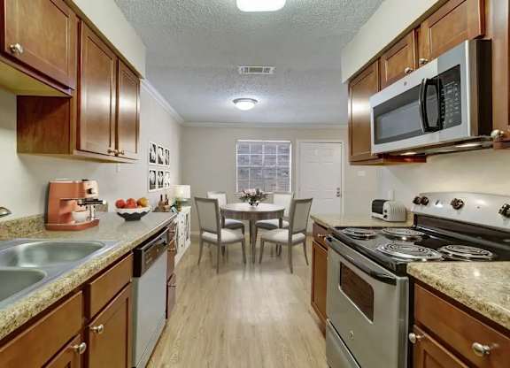 A kitchen with wooden cabinets and a stove top oven.