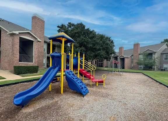 A playground with a blue slide and a yellow and red slide.