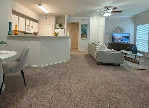 A living room with a grey couch and a white table.