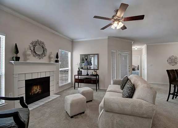 A living room with a fireplace and a ceiling fan.