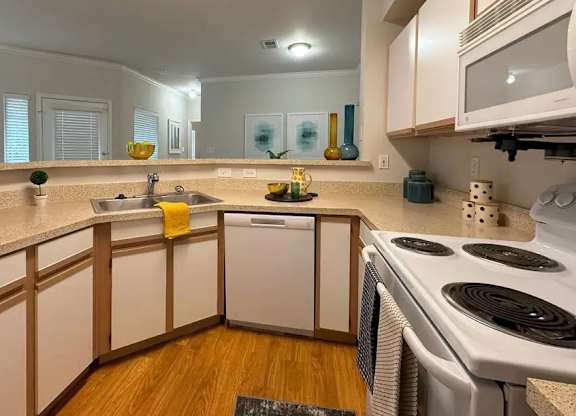 A kitchen with white appliances and wooden cabinets.