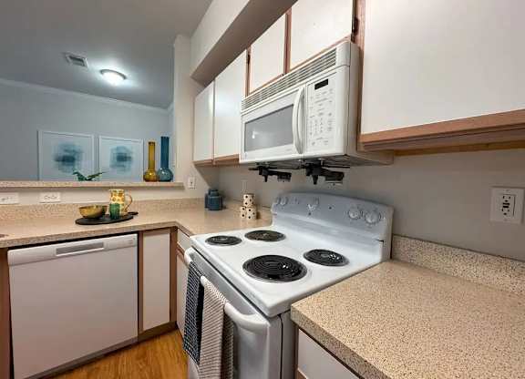 A white stove and microwave in a kitchen.