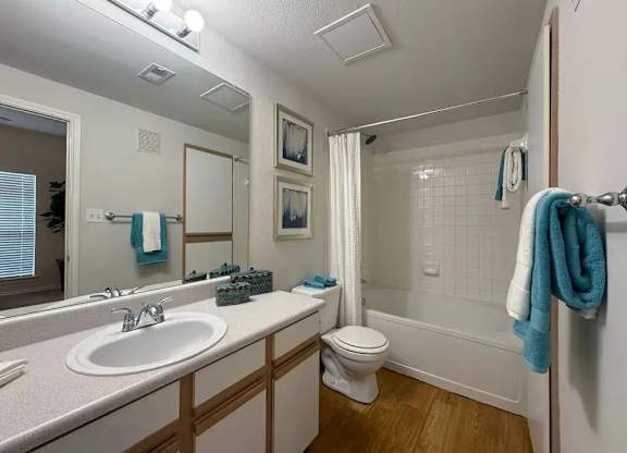 A bathroom with a white sink, toilet, and bathtub.