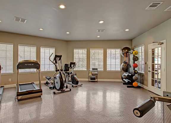 A spacious home gym with treadmills, elliptical machines, and other exercise equipment.