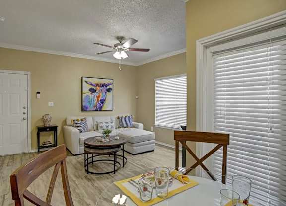 A living room with a white couch, a coffee table, and a painting on the wall.