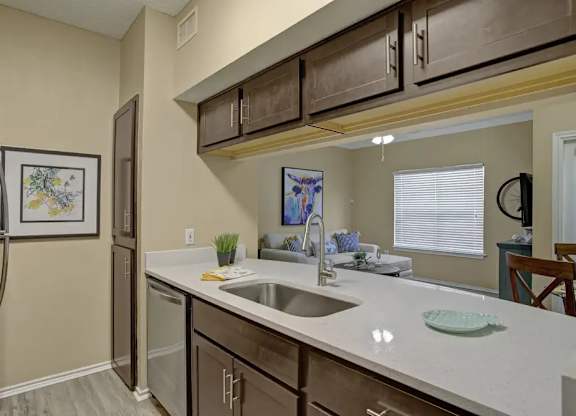 A kitchen with a white counter top and brown cabinets.