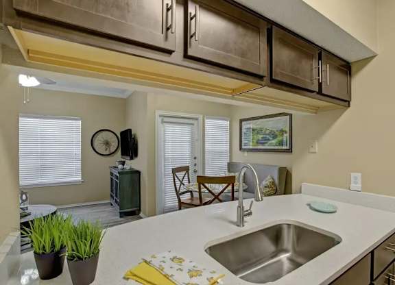 A kitchen with a sink and a clock on the wall.