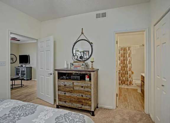 A bedroom with a bed, a dresser, and a mirror.