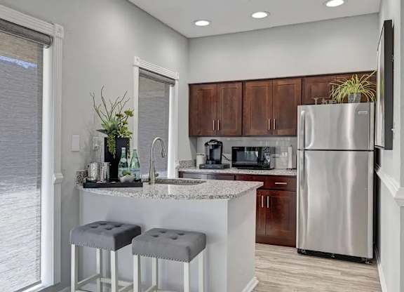 A kitchen with a bar stool and a counter.