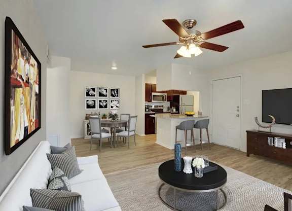 A living room with a white couch and a ceiling fan.
