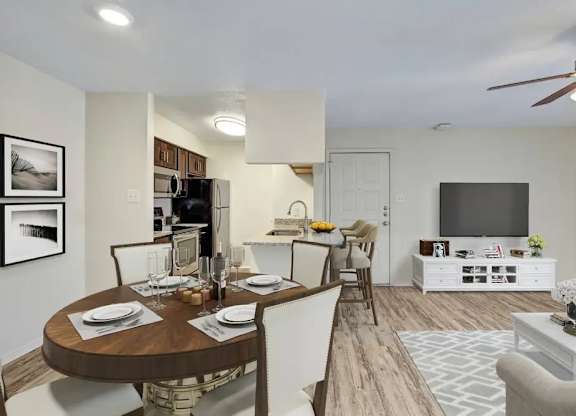 A modern dining room with a wooden table set for two.