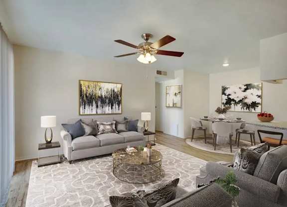 A living room with a grey couch, a coffee table, and a painting on the wall.