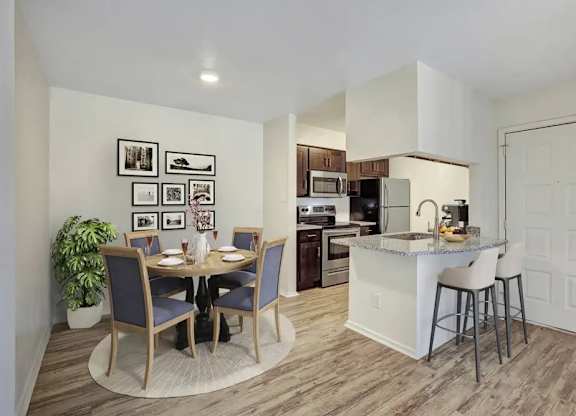 A kitchen with a dining table and chairs.