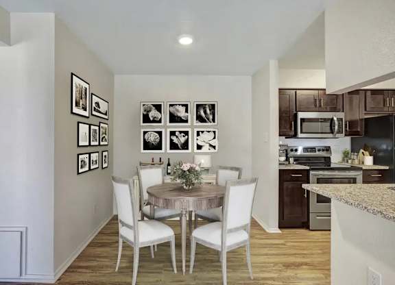 A kitchen with a table and chairs in the middle of the room.