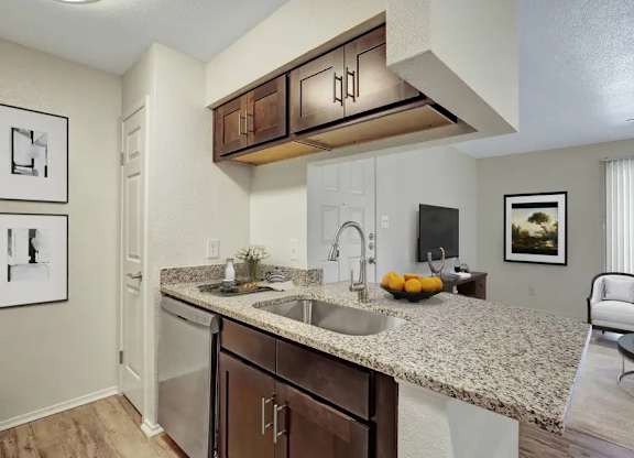 A kitchen with a granite countertop and a sink.