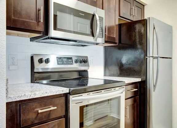 A kitchen with a white refrigerator, stove, and oven.