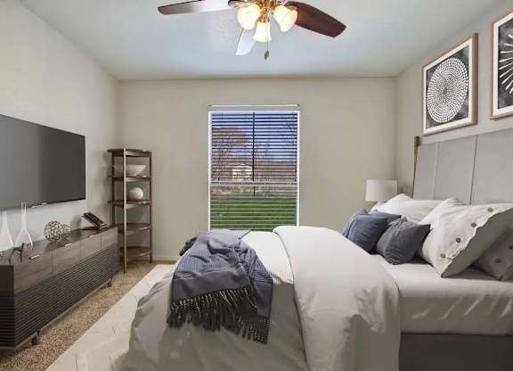 A bedroom with a bed, a television, and a window with blinds.
