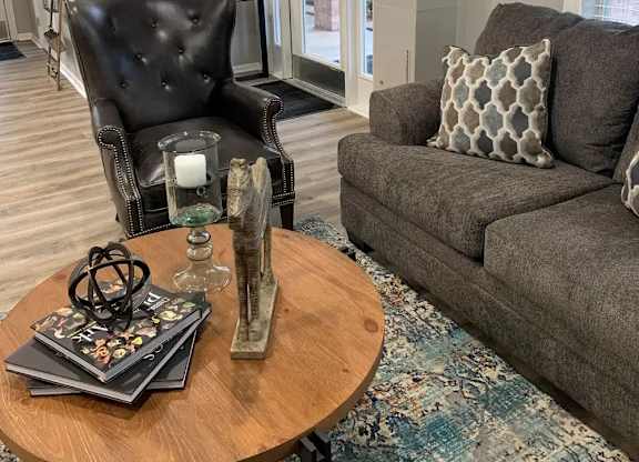 A living room with a black leather chair and a grey couch.